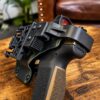Rotating hood and thumb-lever release with Safariland QLS fork mounted on the holster back